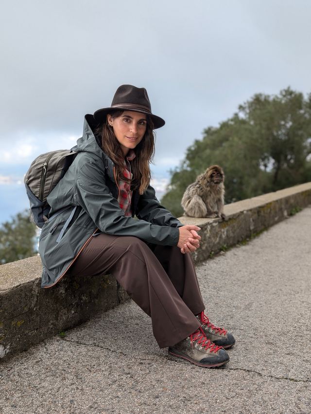 Mia Canestrini seduta su un muretto accanto a una bertuccia